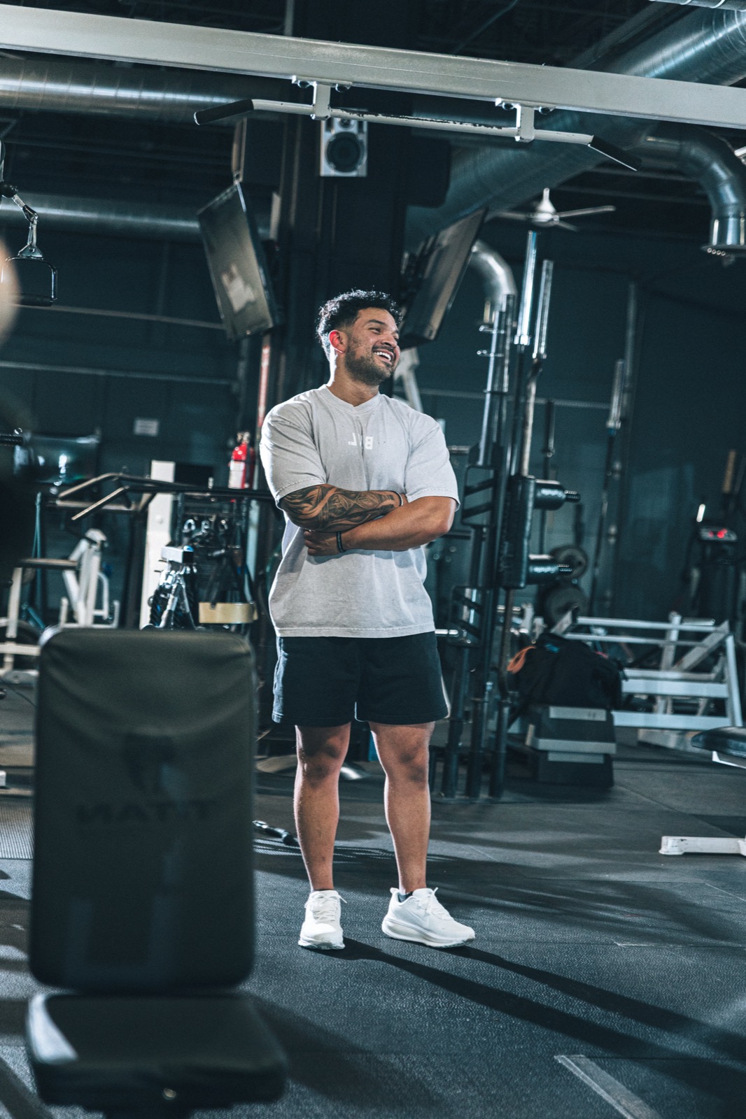 Elijah laughing in the gym, arms crossed.