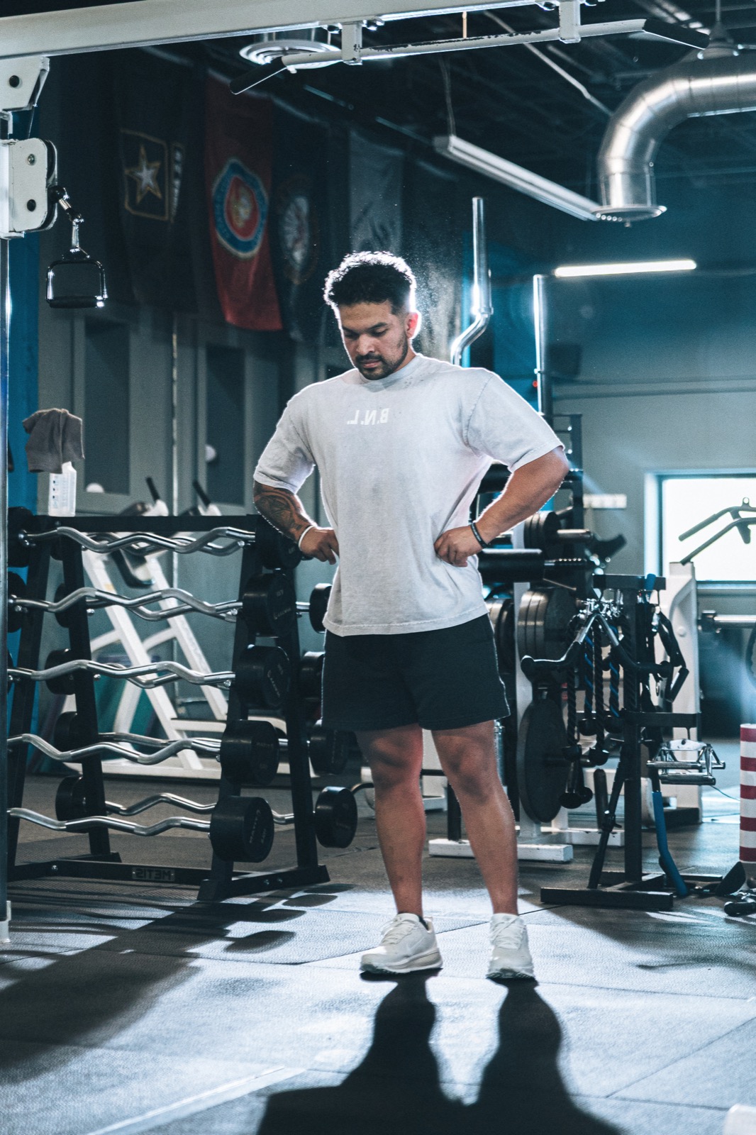 Elijah standing in the gym before a session, head down, focused.