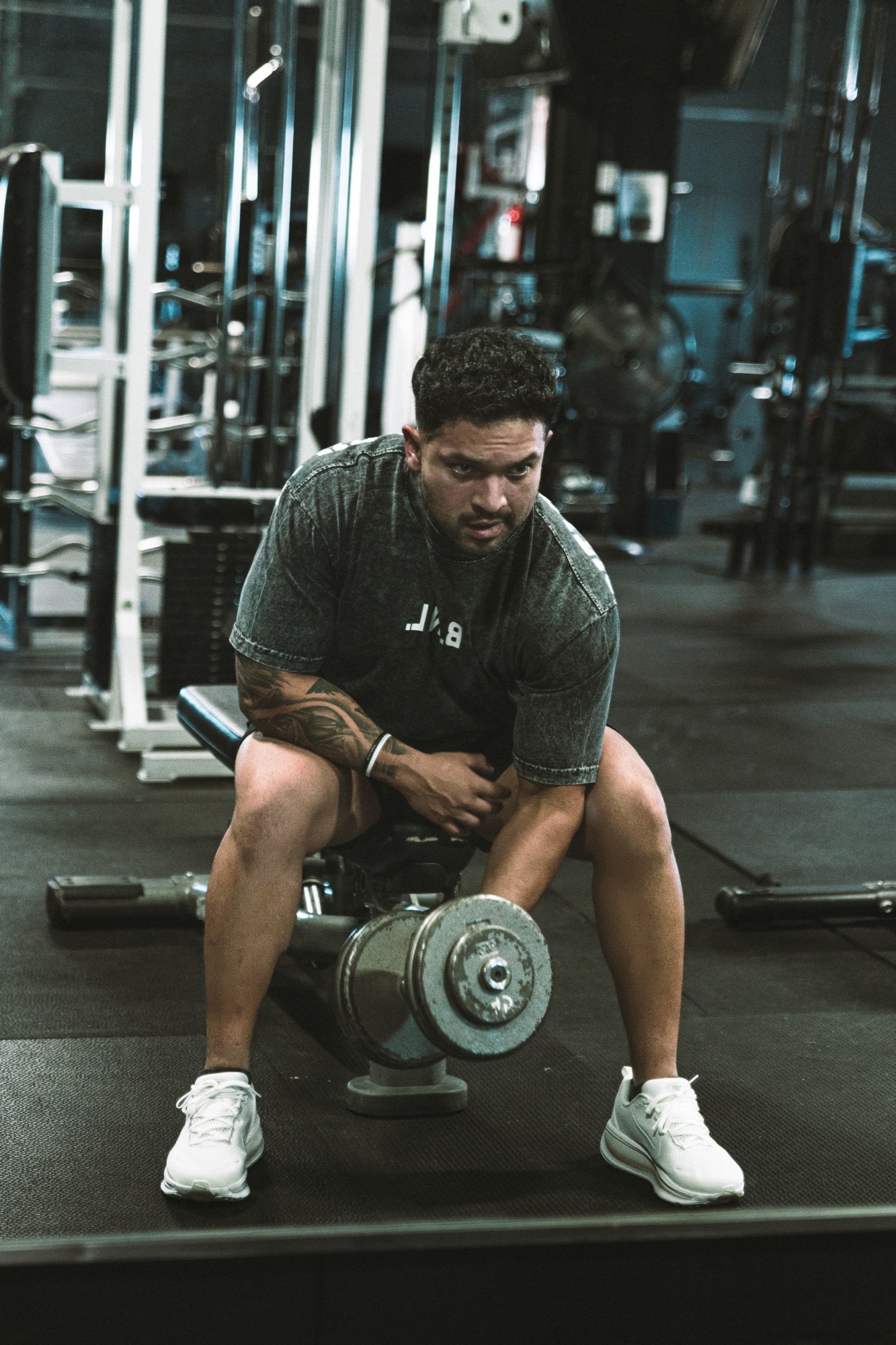 Elijah reaching for the next dumbbell mid-workout.